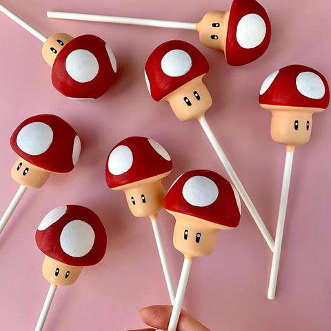 Group of power-up mushroom cake pops arranged for a party dessert table.